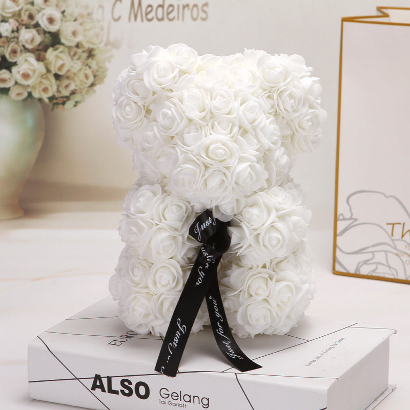 Ours créatif en roses blanches avec ruban noir décoratif sur boîte cadeau élégante
