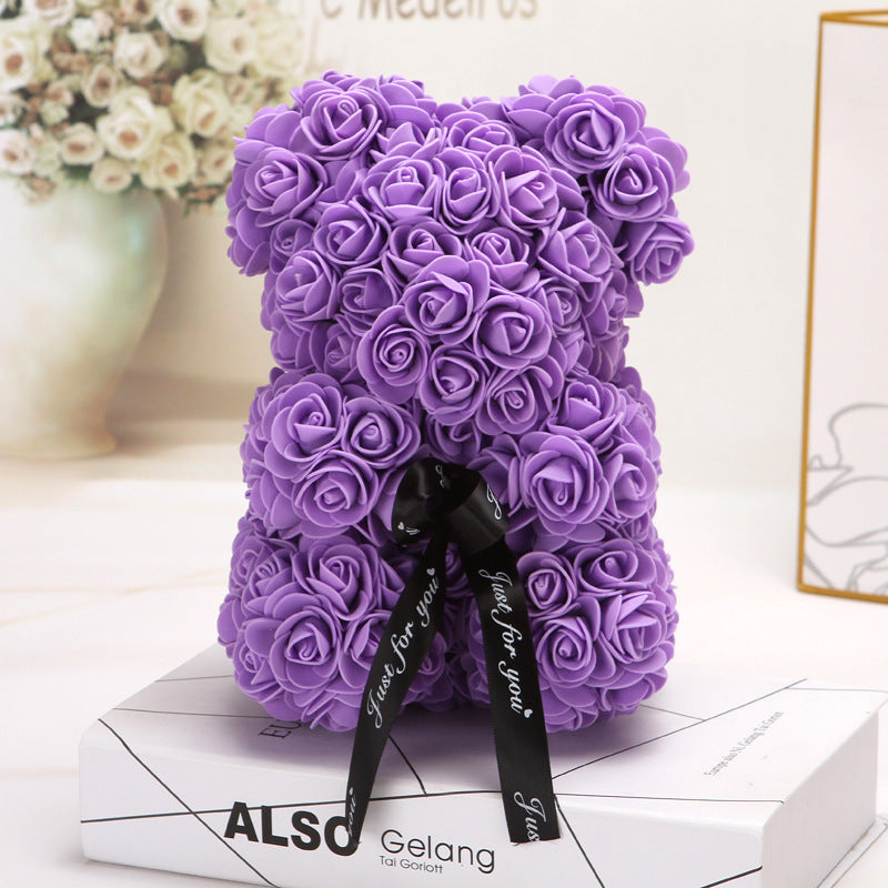 Ours créatif fait de roses violettes avec un ruban noir décoratif.