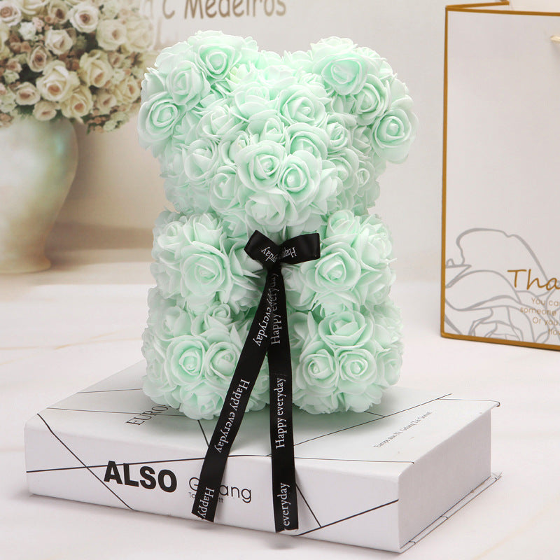 ours créatif fait de roses vert pâle avec un ruban noir décoratif